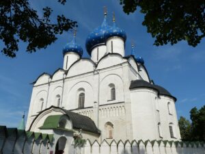 Bild zeigt weiße Kirche mit blauen Kuppeln in Susdal