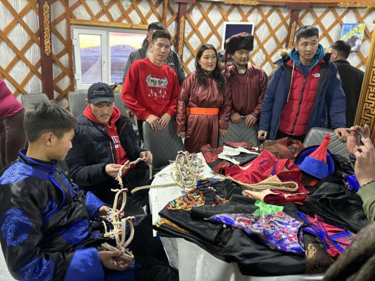 Bild zeigt Nomaden in der Monglei in einer Jurte. Es sind 6 Personen in landesüblicher Tracht der mongolischen Nomaden