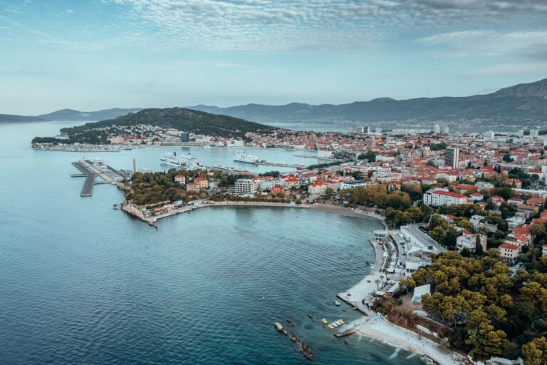 Das Bild zeigt eine Luftaufnahme von Split in Kroatien, im Hintergrund sind die Berge, im Vordergrund die Adria.