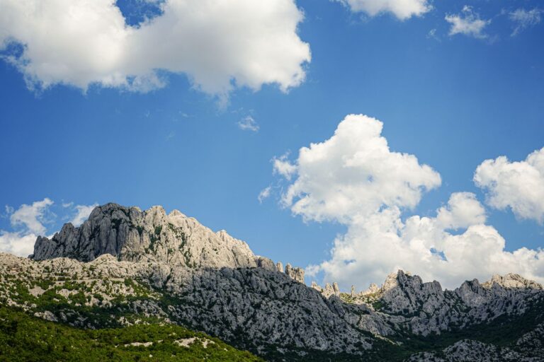 Das Bild zeigt eine Felsformation im Nationalpark Paklenica mit blauem Himmel und weißen Wolken.